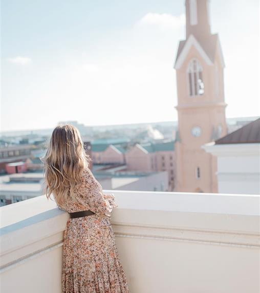 woman on balcony staring at church stemple