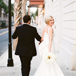 A bride smiles while looking over her shoulder