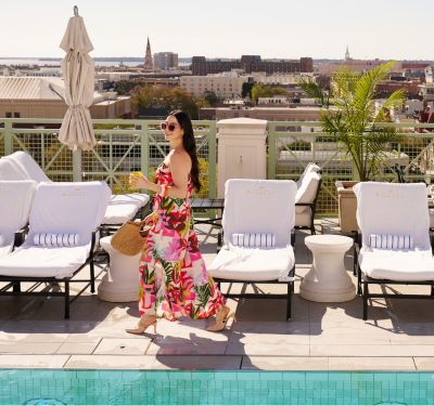 woman with colorful dress beside rooftop pool