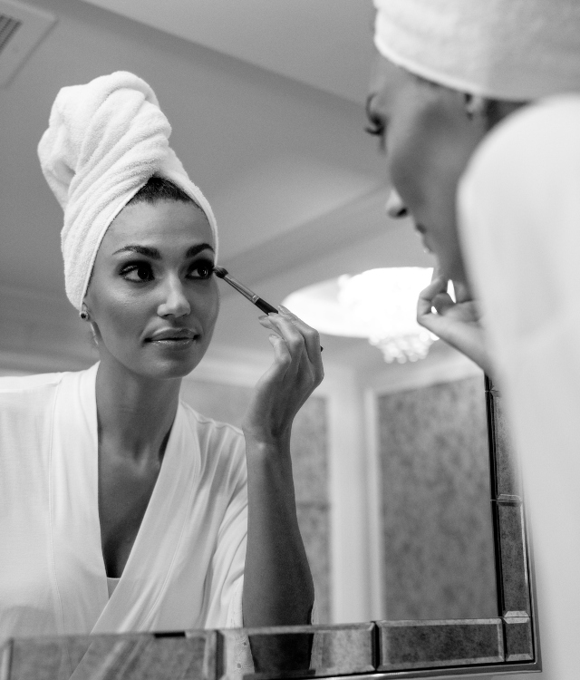 Women looking in the mirror while applying makeup