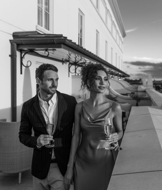 A black and white photo of a couple drinking champagne